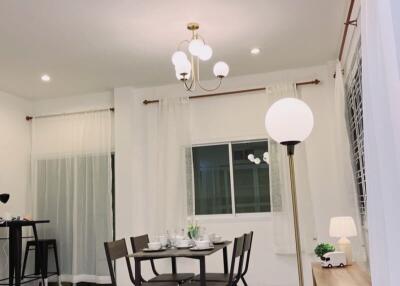 Modern dining room with table and chairs, chandelier, and large window