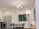 Modern dining room with table and chairs, chandelier, and large window