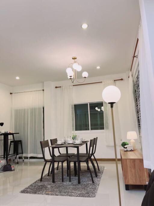 Modern dining room with table and chairs, chandelier, and large window