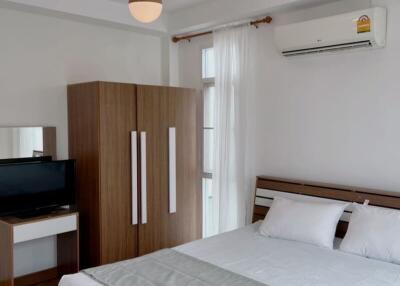 Modern bedroom with bed, wardrobe, and air conditioning