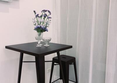 Small kitchen table with two stools and flowers