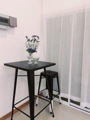 Small kitchen table with two stools and flowers