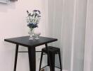 Small kitchen table with two stools and flowers