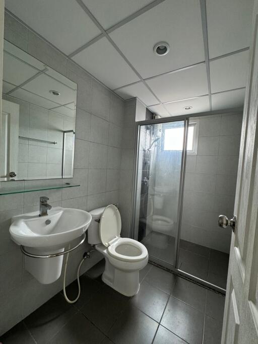 Modern bathroom with glass shower door and tiled walls