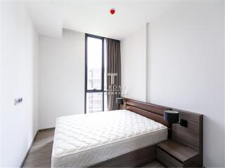 Modern bedroom with a large window, bed, and nightstands