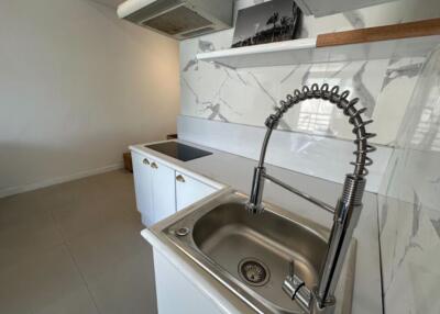 modern kitchen with marble backsplash and stainless steel sink