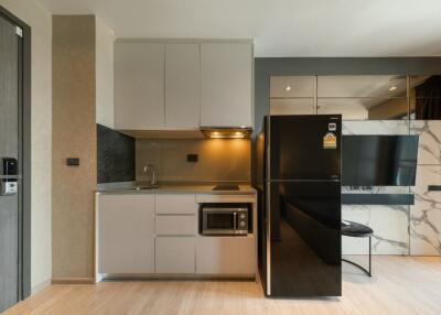 Modern kitchen with appliances including refrigerator and microwave