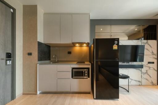 Modern kitchen with appliances including refrigerator and microwave