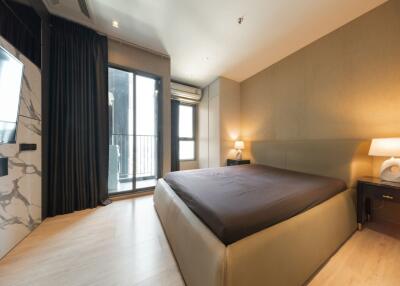 Modern bedroom with a large bed and balcony access