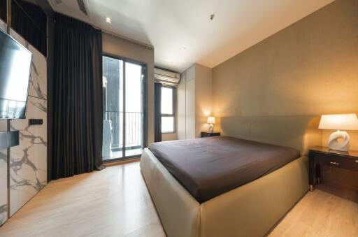 Modern bedroom with a large bed and balcony access