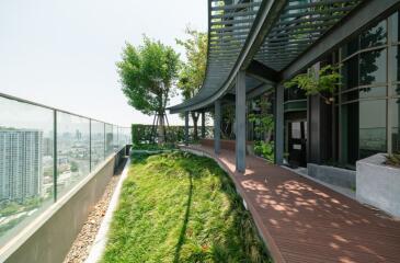 Modern building exterior with green rooftop garden and city view