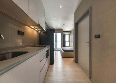 Modern kitchen area with view towards bedroom and balcony