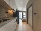 Modern kitchen area with view towards bedroom and balcony