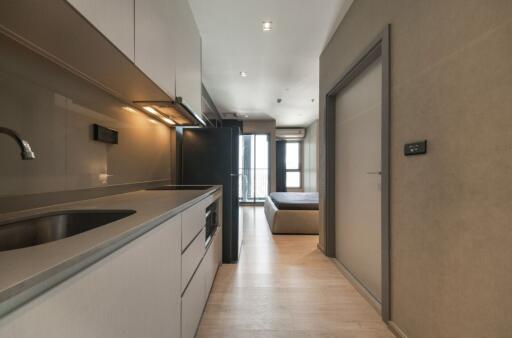 Modern kitchen area with view towards bedroom and balcony