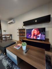 Modern living room with TV, coffee table, and shelving