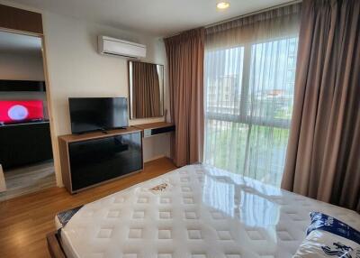 Modern bedroom with large window and TV