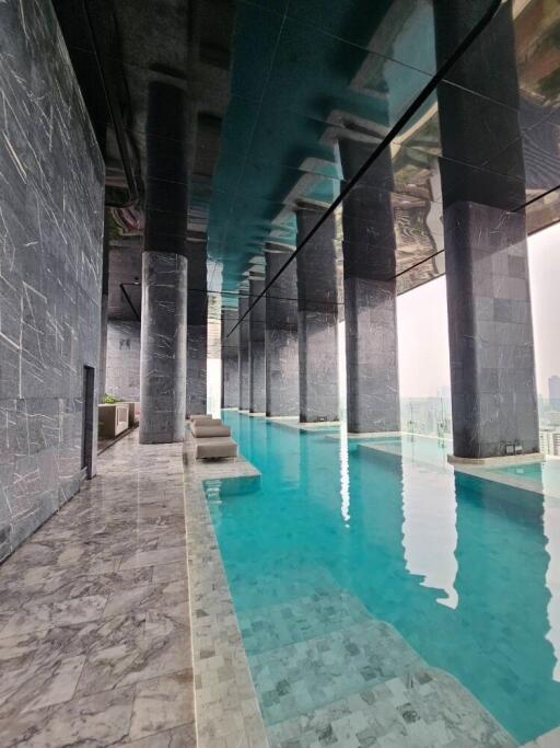 Indoor swimming pool with high ceilings and city view