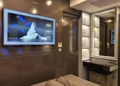 Modern bedroom with wall-mounted TV and vanity mirror