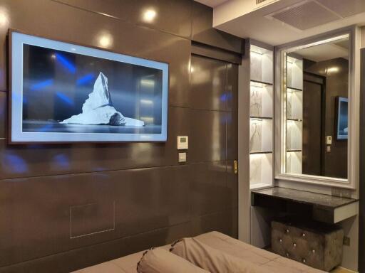 Modern bedroom with wall-mounted TV and vanity mirror