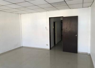 Empty room with tiled floor and ceiling grid