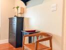 Entrance area with a wooden chair, small table, cabinet, and wall-mounted shelf with hooks