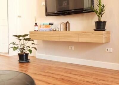 Modern living room with wall-mounted TV and wooden shelf