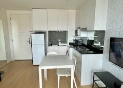 Modern kitchen and dining area with white cabinets and black countertop