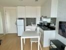 Modern kitchen and dining area with white cabinets and black countertop