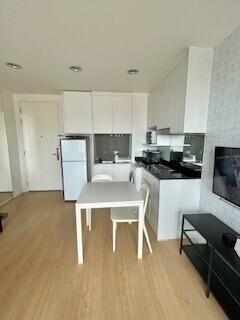 Modern kitchen and dining area with white cabinets and black countertop