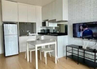 Modern kitchen and dining area with appliances and TV