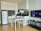 Modern kitchen and dining area with appliances and TV