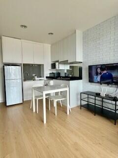 Modern kitchen and dining area with appliances and TV