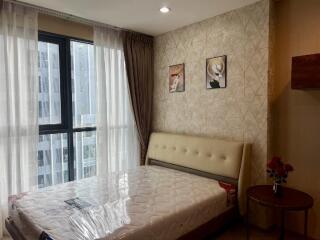 Bedroom with large window, bed, and decorative wall art