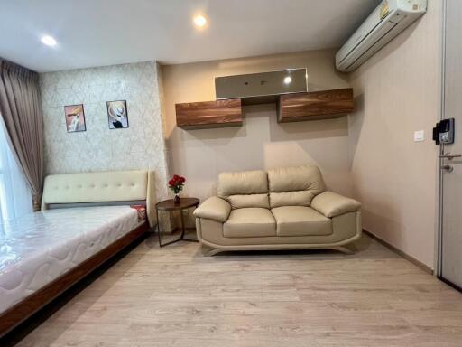 Modern living room with beige leather sofa and wall-mounted shelves