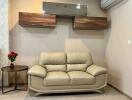 Living room with beige leather sofa and wall-mounted shelves