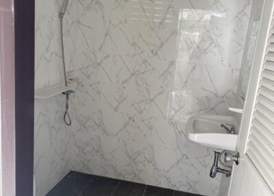 Clean bathroom with marble walls and black tile floor