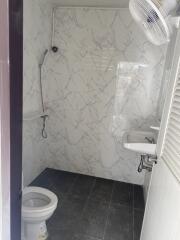 Clean bathroom with marble walls and black tile floor