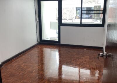 Empty bedroom with parquet flooring and large window