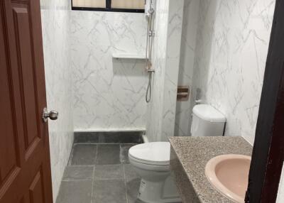 Modern bathroom with marble walls and gray floor tiles