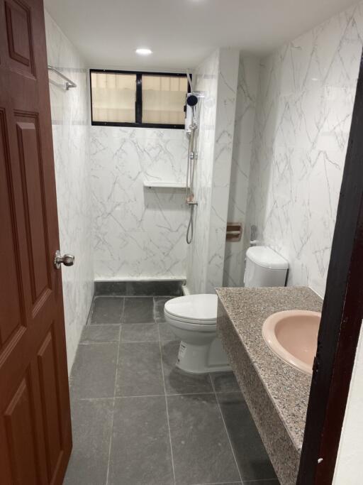 Modern bathroom with marble walls and gray floor tiles