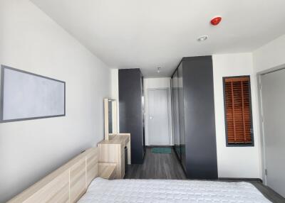 A modern bedroom with a bed, wardrobe, and a mirror