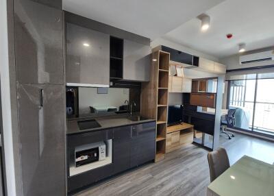 Modern kitchen and living space with built-in cabinets and workspace