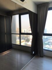 Bedroom with large wardrobe and windows offering city view