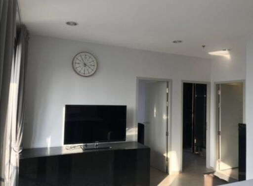 Living room with a TV and wall clock