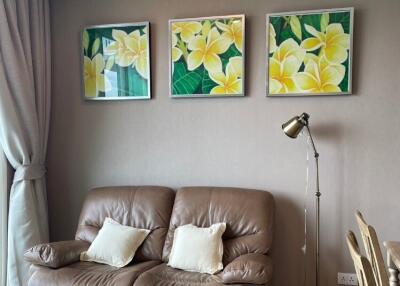 Cozy living room with brown leather sofa, decorative wall art and floor lamp