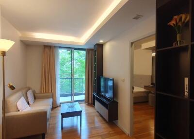 Modern living room with a sofa, TV, and view of balcony