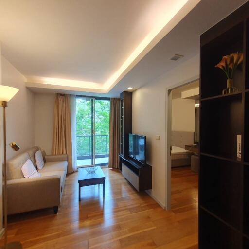 Modern living room with a sofa, TV, and view of balcony