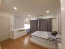 Spacious bedroom with natural lighting and modern furnishings