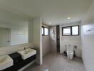 Modern bathroom with dual sinks, shower, and toilet