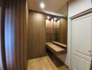 Modern walk-in closet with wooden panels and a mirrored wall